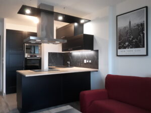 Cuisine moderne noire avec îlot central, installation réalisée par Homesweety à partir d’un modèle Castorama.