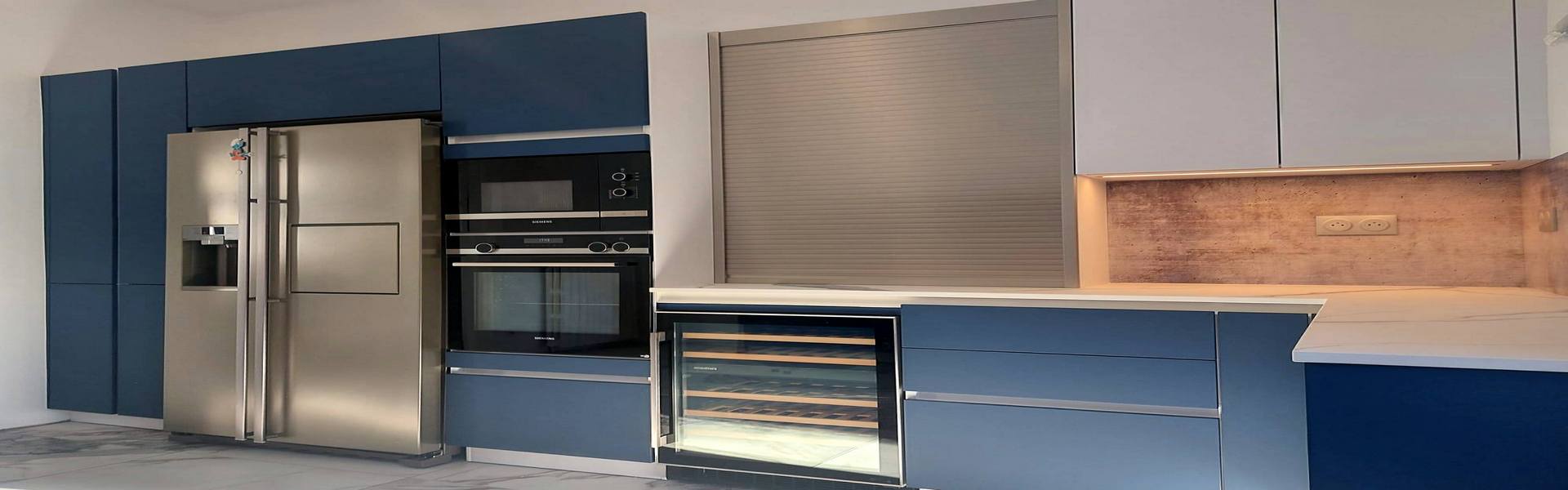 Cuisine moderne bleue avec réfrigérateur inox, four encastré et cave à vin intégrée